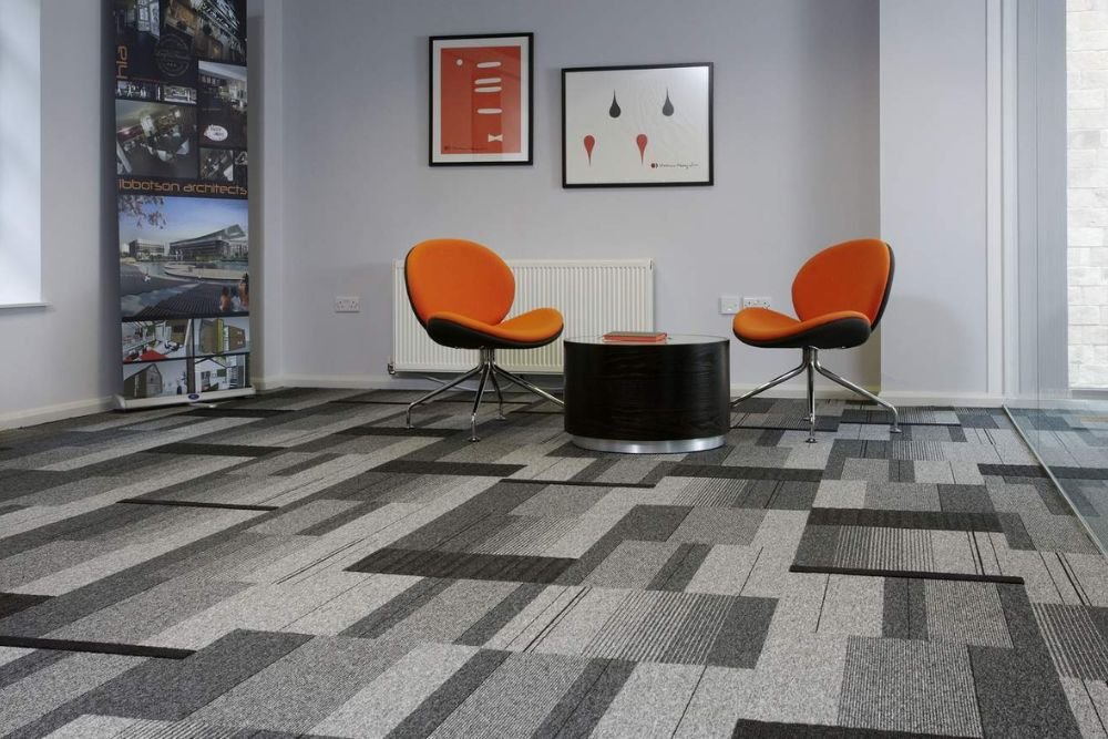Modern office space with grey carpet and vibrant orange chairs, representing a flooring service based in Seattle, WA.