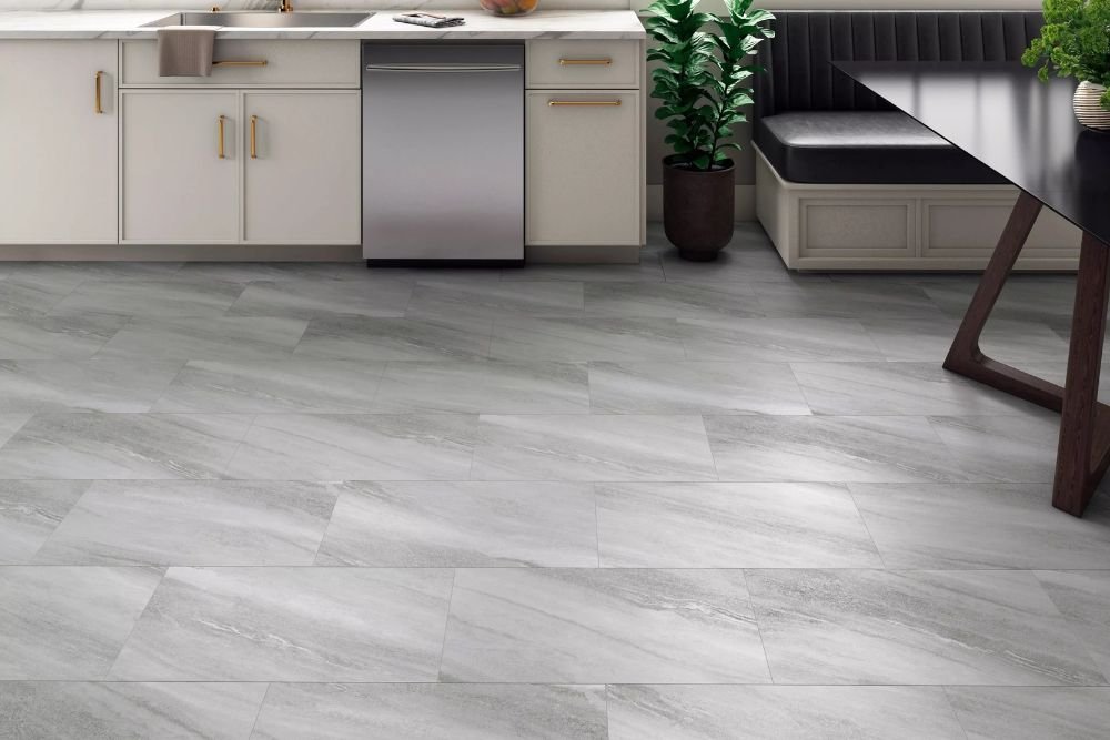 Contemporary kitchen design with white cabinets and gray tile flooring, representing luxury vinyl tile services in Seattle, WA.